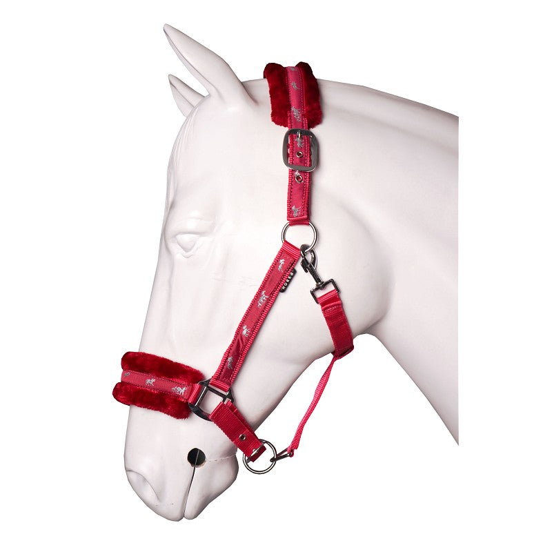 A plush red horse halter with soft fur lining on the noseband and headpiece, displayed on a white horse mannequin. Horka. Available with Nice Equestrian Wukair Doha Qatar
