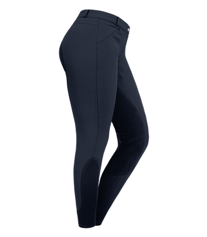 A pair of navy blue women's riding breeches with elastic leg cuff and synthetic leather full seat, featuring two front zip pockets and belt loops.