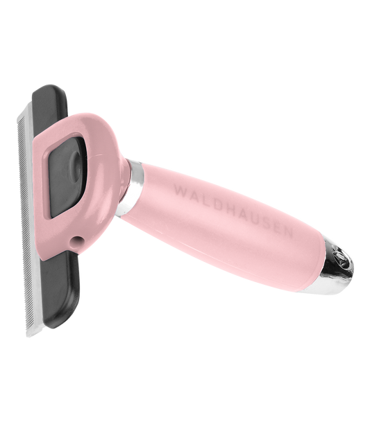 A pink horse grooming comb with a gel handle and the brand name Waldhausen visible on the side.